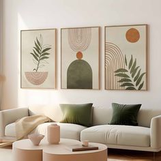 three paintings hang on the wall above a white couch and coffee table in a living room