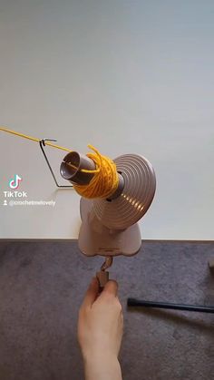 a person is working on something with a yellow wire attached to the top of it