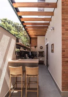 two wicker chairs sitting on top of a patio next to a table and bar