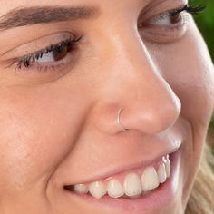 a close up of a woman's face with her nose ring in front of her