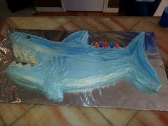 a cake shaped like a shark with candles on it