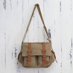 Crafted of sturdy tan canvas this roomy messenger bag keeps things organized. Four outer pockets are easily accessible while a zipper pocket is hidden on the inside of the flap. By Karina and Maybee the bag is lined in beige and opens to reveal another zipper pocket. Leather trim adds to its appeal and the shoulder strap is adjustable in length. Cheap Khaki Canvas Satchel Bag, Affordable Vintage Canvas Satchel, Affordable Khaki Canvas Satchel Bag, Cheap Light Brown Bag With Adjustable Strap, Affordable Brown Vintage Canvas Bag, Cheap Brown Satchel With Zipper Pocket, Cheap Brown Chest Bag With Pockets, Cheap Light Brown Satchel Bag, Casual Light Brown Cheap Satchel