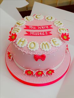 a pink cake with white frosting and red flowers on the top that says you were missed