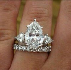 a woman's engagement ring with two pear shaped diamonds on the top and bottom