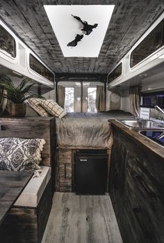 the interior of a camper with wood paneling and white walls, including a bed