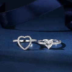 two heart shaped engagement rings on a blue background