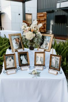 a table topped with pictures and flowers on top of a white cloth covered tablecloth