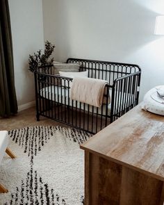 a baby crib in the corner of a room with a rug on the floor