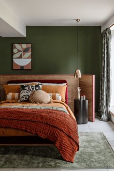 a bed sitting next to a window in a room with green walls and carpet on the floor