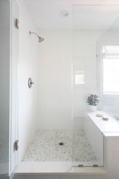 a bathroom with a walk in shower next to a bathtub and sink under a window