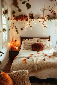 a bedroom decorated with fall leaves and string lights