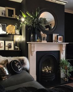 a living room with a fireplace and pictures on the wall above it's mantle