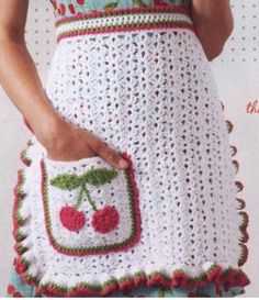 a crocheted apron with cherries on it and a pocket in the front