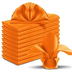 a stack of orange napkins next to an orange bow on top of each other