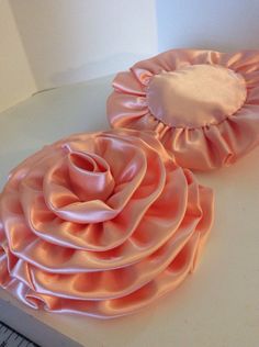 two large pink flower hair clips sitting on top of a table