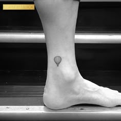 a small hot air balloon tattoo on the ankle