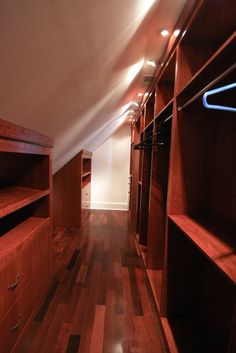 an empty closet with wooden flooring and built - in shelving units on the wall