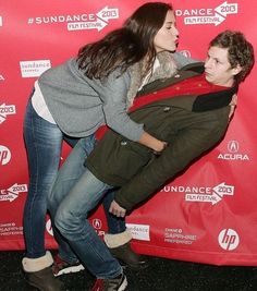 a man and woman posing in front of a red backdrop for the film's premiere