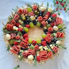 a wreath made out of fruits and veggies is displayed on a tablecloth