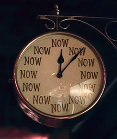 a close up of a clock with words written on the front and back of it