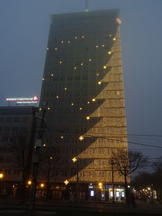 a very tall building with lights on it's side