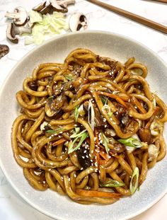 a white plate topped with noodles and mushrooms