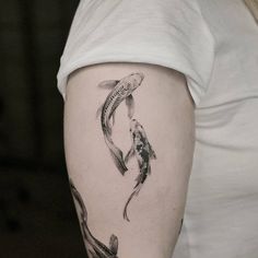 a woman's arm with two koi fish on it