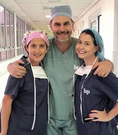 a man in scrubs poses with two nurses