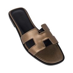 Guaranteed authentic Hermes Oran sandal featured in Vert Bronze.Divine perfect neutral pairs with anything in your wardrobe!This stunning limited edition Hermes Oran flat slide sandal is featured in Epsom leather.The iconic H cutout over the top of the foot.Embossed calfskin insole. Wood heel with leather sole. Comes with sleepers, signature Hermes box and ribbon.Please see our extensive collection of Hermes Oran sandals available. NEW or NEVER WORN.final saleSIZE 36.5USA SIZE.6.5CONDITION: NEW Luxury Slide Mules, Luxury Slide Mules With Leather Footbed, Luxury Summer Flats With Round Toe, Luxury Round Toe Flats For Summer, Luxury Slide Sandals With Leather Footbed, Elegant Gold Flat Slides, Luxury Leather Sole Slide Mules, Luxury Flat Mules With Leather Lining, Luxury Mules With Leather Footbed And Flat Heel