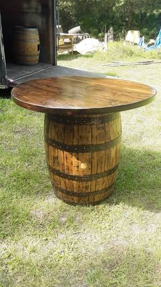 a wooden barrel table sitting in the grass