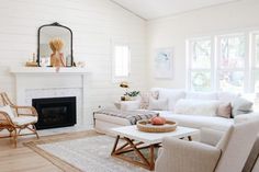 a living room filled with furniture and a fire place in front of a mirror on the wall