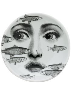 a plate with fish on it and a woman's face painted on the side