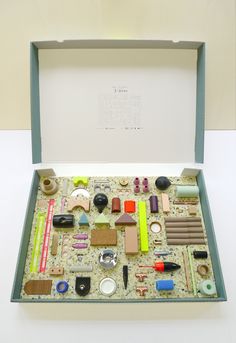 an open box filled with assorted items sitting on top of a white table next to a wall