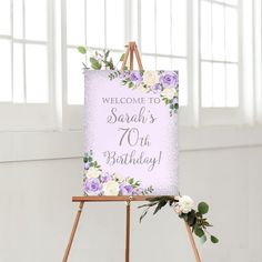 a welcome sign on an easel with flowers