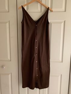 This dress dates from the 1980s, when Calvin was still designing. Cotton jersey deep V-neck buttonfront dress has his signature foldover shoulder strap detail, shown in last photo. Onseam side pockets. Size 4, very slim cut through the body (does not come close to fitting on today's size 6 dress form), dress has subtle flare below the hips. Recommended for size 4 at most, even better for size 2.  Color Brown.  Never worn.  Dimensions: 31" circumference at armpit  34" circumference at approximate hip Garment length shoulder to hem 42" Cotton V-neck Midi Dress With Button Closure, Cotton V-neck Midi Dress For Date Night, Vintage V-neck Buttoned Midi Dress, Vintage V-neck Midi Dress With Buttons, Brown V-neck Midi Dress With Buttons, Form Dress, Vintage Calvin Klein, Button Front Dress, Calvin Klein Dress