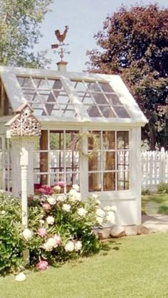 a small white house sitting in the middle of a garden