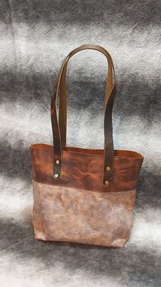 "Hand stitched using premium ghost waxed crazy horse leather with water buffalo straps. Solid brass rivets and an inside pocket. This leather will patina to a beautiful dark and shiny brown over time. Approximate body size: 13\"x12\"x5\" Handle height: 12\" above bag" Rugged Bags With Leather Handles And Oiled Leather, Rugged Shoulder Bag With Oiled Leather And Leather Backing, Vintage Bag With Leather Handles And Oiled Leather, Vintage Bag With Leather Handles In Oiled Leather, Rugged Oiled Leather Shoulder Bag With Leather Backing, Rugged Distressed Brown Bag With Waxed Finish, Distressed Brown Leather Shoulder Bag With Leather Handles, Brown Oiled Leather Bag With Leather Handles, Vintage Brown Vegetable Tanned Leather Bag