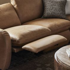 a living room with a brown couch and two pillows on the back of the couch