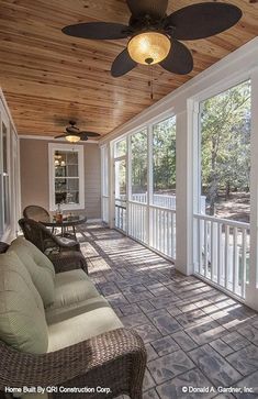 a screened porch with wicker furniture and ceiling fan