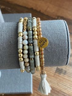 This 4mm gray stack consists of 5 bracelets, perfect for everyday wear and every occasion.  *In this stack you will receive* * 2 Heishi bracelets with gold round beads and an S&L charm.   * Brown Spotted beads with a light gray tassel.  * Natural stone bead in clear and gray with gold spacers.  * Bamboo Leaf bead with gold accent.   All S&L Stackz come in a muslin bag for easy storage and gifting! If you need a special gift for that someone, these stacks are perfect!  Bracelets are made with quality stretchy elastic material. Heishi bracelets have double elastic.  >> Try rolling one bracelet at a time << >>Do not over stretch<< > Please keep in mind, this stack is made to order. FINAL SALE > Color & size of beads may vary due to supply.  > Follow instructions of care. Keep away from water Stretch Beaded Bracelets Diy, Heishi Bracelets, Stackable Beaded Bracelets, Stack Bracelet, Bracelets Design, Gold Armband, Beads Bracelet Design, Natural Stone Bracelets, Beaded Bracelets Diy