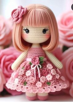 a crocheted doll is standing in front of pink roses with her hands on her hips