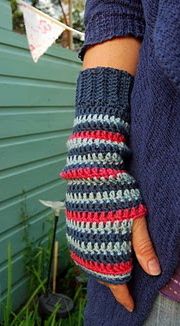 a person wearing a pair of crocheted arm warmers in front of a house