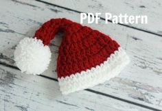 a red and white knitted santa hat with pom - pom on top