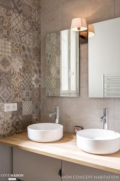 two white sinks sitting next to each other on top of a wooden counter in a bathroom