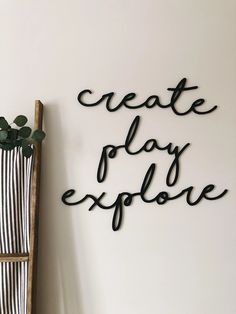 a wooden chair sitting next to a wall with the words create play explore written on it