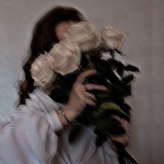 a woman holding flowers in front of her face