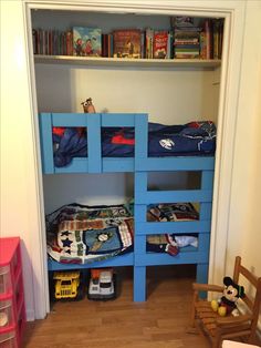 bunk beds made out of pallets in a child's room with toys and bookshelves