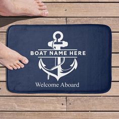 two people standing next to a bath mat with an anchor and welcome aboard sign on it