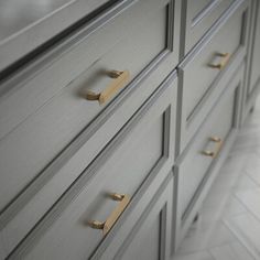 a close up of a dresser with brass handles