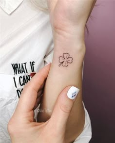 a woman with a small four leaf clover tattoo on her left wrist and the word what if i can't do?